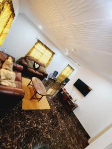 uma sala de estar com um sofá e uma mesa em Malikia apartment 2 em Brusubi