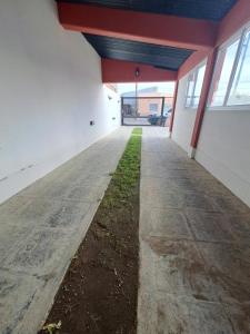 un couloir vide d'un bâtiment avec de l'herbe au milieu dans l'établissement Vientos del Sur, à Río Gallegos