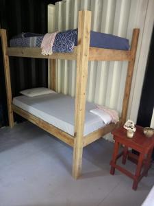 Litera de madera con colchón blanco y mesa en TOnat Caribe Hostel, en West End