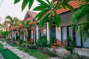 a house with a courtyard with chairs and trees at Sawit Garden Cottages in Nusa Penida