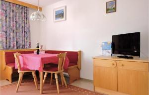 a dining room with a table and a television at Cozy Apartment In Kappl With House A Mountain View in Kappl