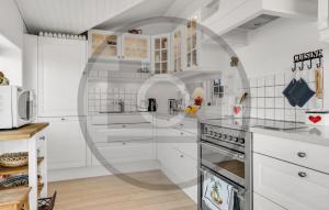 una cocina blanca con armarios y electrodomésticos blancos en Beautiful Home In Varde With Kitchen, en Varde