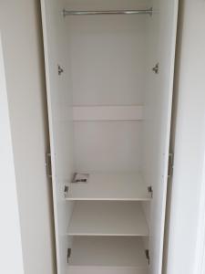 a white closet with white shelves in a room at The Garden House in Sydney