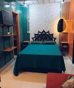 a bedroom with a green bed and a tv at BRÁS Expo Center Norte Feira da Madrugada, shopping vautier 25 março in Sao Paulo