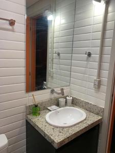 een badkamer met een wastafel en een spiegel bij BRÁS Expo Center Norte Feira da Madrugada, shopping vautier 25 março in Sao Paulo
