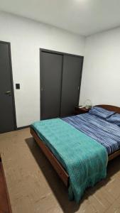 1 dormitorio con 1 cama con edredón azul en Departamento Ñandú - 2 ambientes zona Güemes en Mar del Plata