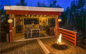 a wooden deck with a table and a fire at Pet Friendly Home In Gressvik With House A Panoramic View in Gressvik