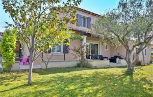 a house with trees in front of a yard at Maison Le Pavillon in Graveson