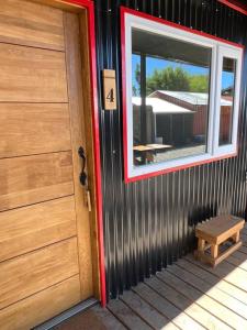 una puerta a una casa con un banco al lado en Departamento duplex 4, en Puerto Natales