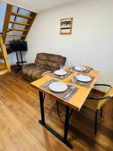una sala de estar con una mesa con platos. en Departamento duplex 4, en Puerto Natales 1 foto más