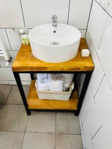 y baño con lavabo y toallas en una estantería de madera. en Departamento duplex 4, en Puerto Natales