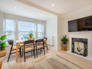 une salle à manger avec une table, des chaises et une cheminée dans l'établissement Sea Breeze, à Torquay