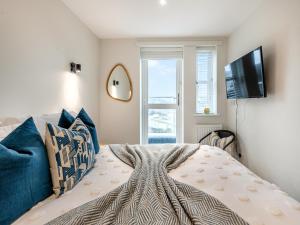 1 dormitorio con 1 cama y TV de pantalla plana en Sea Breeze en Torquay