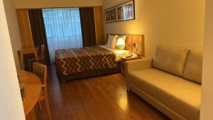 um quarto de hotel com uma cama e um sofá em Hotel Alphaville em Barueri