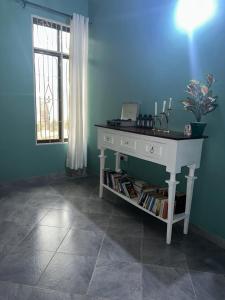 Un escritorio blanco en una habitación azul con ventana en Stay with Tiffany, en Dar es Salaam