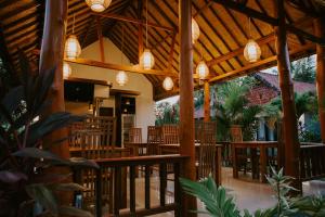 a restaurant with wooden tables and chairs and lights at Sawit Garden Cottages in Nusa Penida