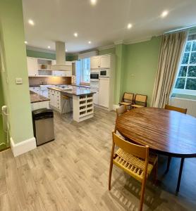 a kitchen with a wooden table and a dining room at Picturesque Thameside Apartment in Henley on Thames