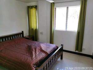 Un dormitorio con una cama grande y una ventana en Tropicasa Siquijor Seafront Guest House en Solangon