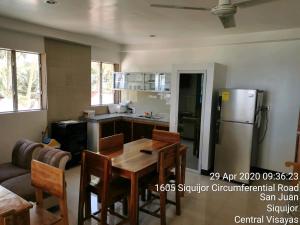 uma cozinha com uma mesa e um frigorífico em Tropicasa Siquijor Seafront Guest House em Solangon