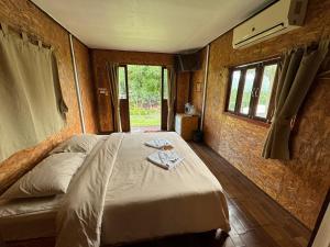 a bedroom with a bed in a room with windows at Mari Pai Resort in Pai