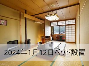 a room with a table and writing on the wall at Yadoya Tsubaki in Aomori