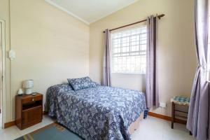 a bedroom with a bed and a window at Paddock Road in Bridgetown