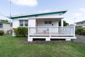 a small white house with a white porch at Paddock Road in Bridgetown