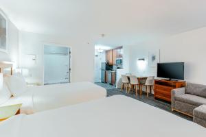 a hotel room with two beds and a flat screen tv at TownePlace Suites Stafford in Stafford