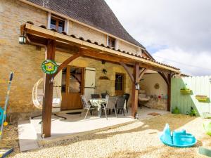 a pavilion with a table and chairs on a patio at Maison familiale près de Limeuil avec jardin, jeux pour enfants, WiFi et animaux acceptés - FR-1-616-84 in Limeuil