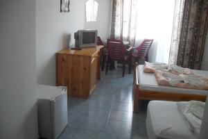 a room with two beds and a tv on a wooden cabinet at Family Hotel Sinemoretz in Sinemorets