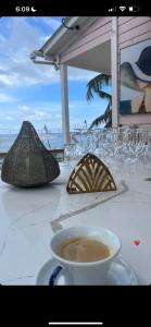 Mano Juan的住宿－Casa rosada beach front，海滩上的桌子,上面放着咖啡和眼镜
