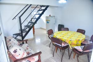 a dining room with a table and chairs and a staircase at Alojamiento Moni in Villa Elisa +1 photo