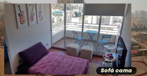 sala de estar con cama morada y balcón en Departamento Viña del mar, en Viña del Mar