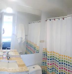 baño con cortina de ducha colorida y lavamanos en Departamento Viña del mar, en Viña del Mar