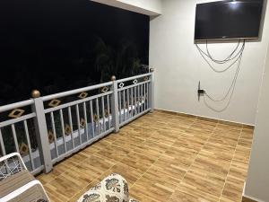 een balkon met een flatscreen-tv aan de muur bij Aparta Hotel Esa Buya in San Fernando de Monte Cristi