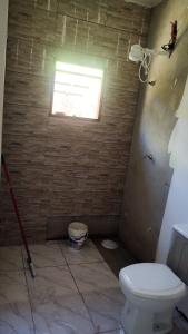 een badkamer met een toilet en een raam bij Chacara em Condomínio in Mairinque