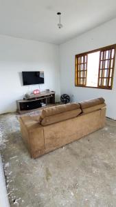 un gran sofá marrón en la sala de estar en Chacara em Condomínio en Mairinque