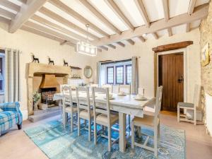 a dining room with a table and chairs and a fireplace at Dale House Farm - Uk46033 in Monyash