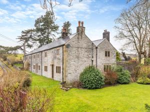 an old stone house in a field of grass at Dale House Farm - Uk46033 in Monyash