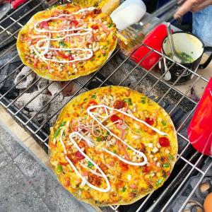 two pizzas sitting on top of a grill at Khách sạn Quang Vinh in Da Lat