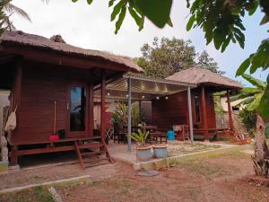 a house with a table and chairs in front of it at Yellow Coco Gili Gede in Gili Gede