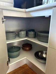 a cupboard filled with plates and bowls and pans at Shepparton House in Shepparton