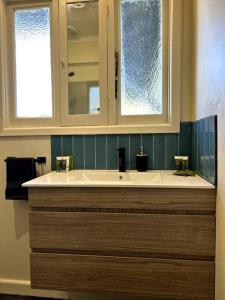 a bathroom with a sink and a mirror at Shepparton House in Shepparton