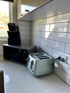 a kitchen with a toaster and a microwave on a counter at Shepparton House in Shepparton