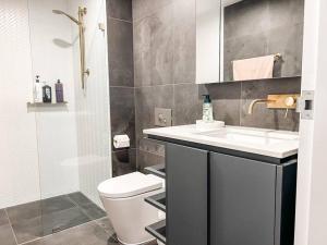 a bathroom with a sink and a toilet and a shower at Metropol - CBD pool Sleeps 7 in Canberra
