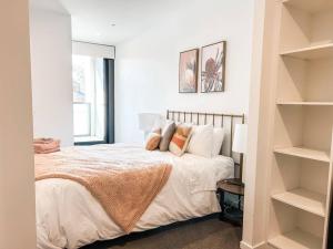 a bedroom with a bed with white sheets and pillows at Metropol - CBD pool Sleeps 7 in Canberra +11 photos