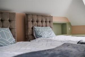 een slaapkamer met een groot bed met witte lakens en kussens bij Traditional Family House Near Beach -Great Garden! in Bournemouth