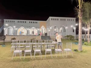 un homme debout devant une table et des chaises dans l'établissement Morocco Villa Mui Ne, à Phan Thiết