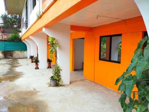 un edificio naranja y blanco con una puerta abierta en AUNORA ROOMS with AC, 