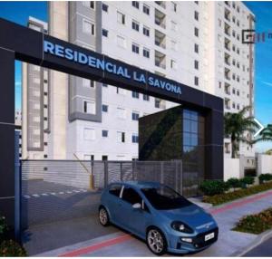 a blue car parked in front of a building at Apartamento com Sacada na Gleba, Novo e equipado in Londrina